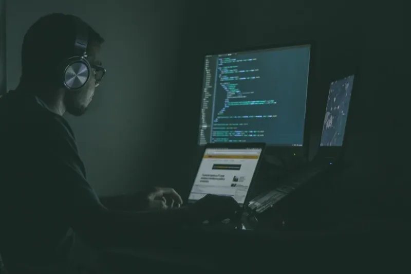 A developer working late into the night surrounded by code — the reality for volunteer open-source maintainers facing an avalanche of AI-generated contributions